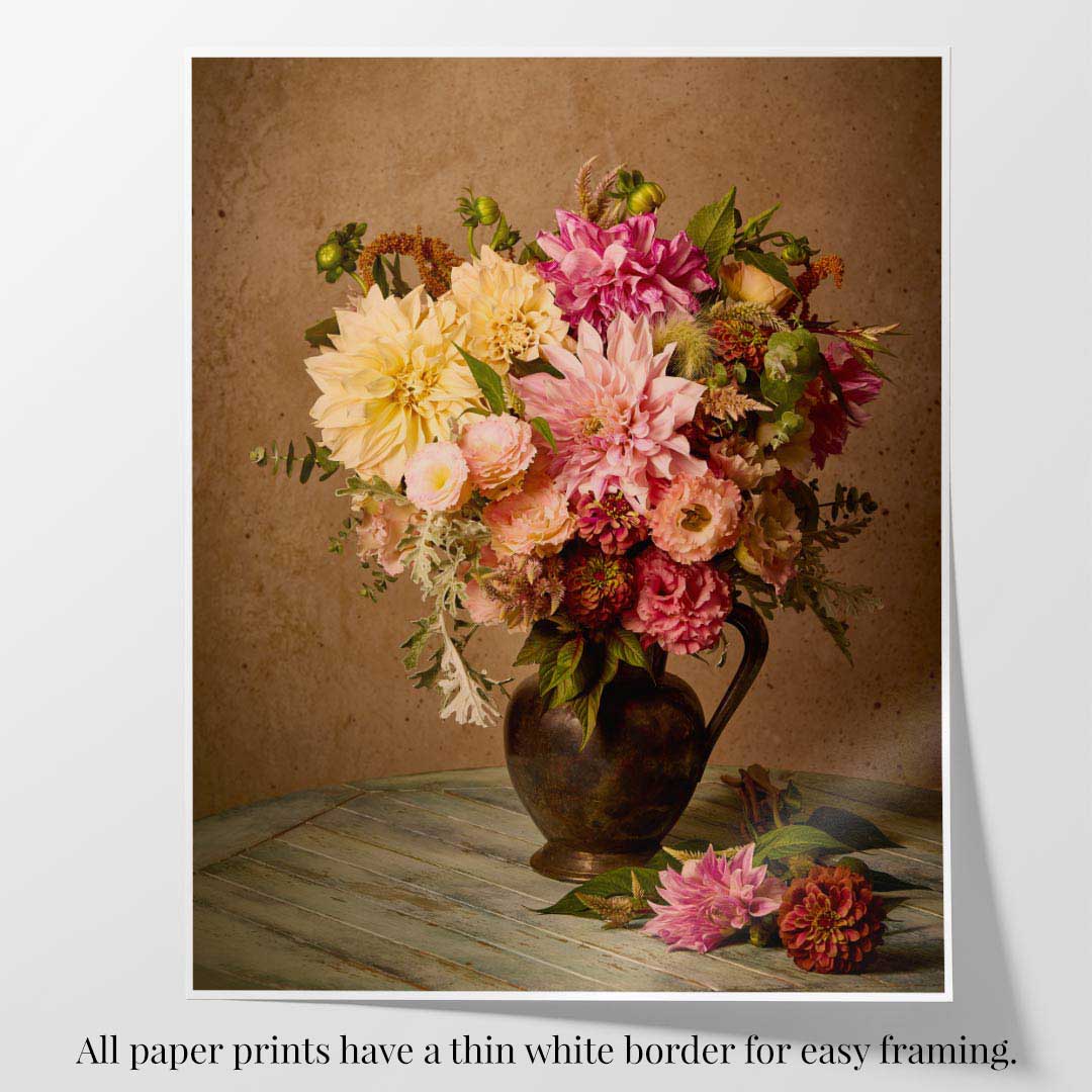 Image of a print with a white border on a white surface. The print is of an image of floral arrangement with dahlias on a weathered teal table with a speckled brown wall in the background
