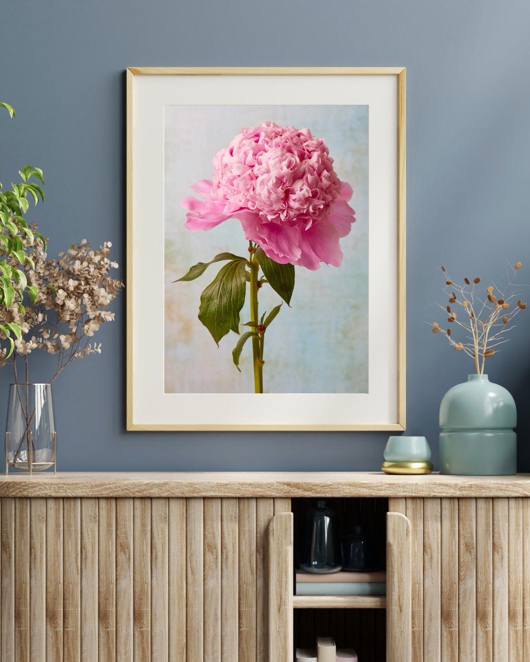 Image of a paper print with a white mat board and a natural wood frame above a cabinet