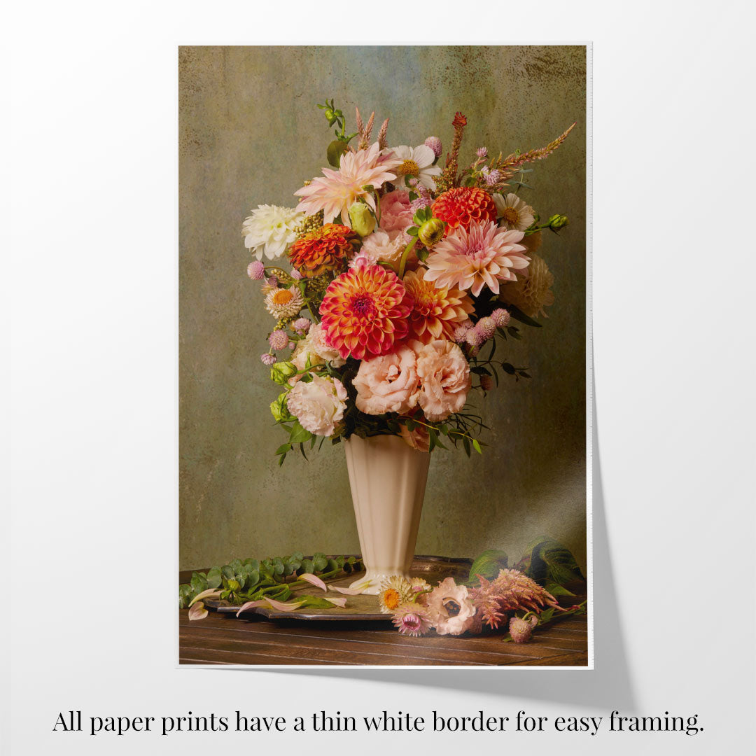 The Victorian Bouquet features a vase with a vibrant mix of pink and orange dahlias and lush green leaves on wood, plus artfully scattered blooms. A thin white border makes it ideal for framing.