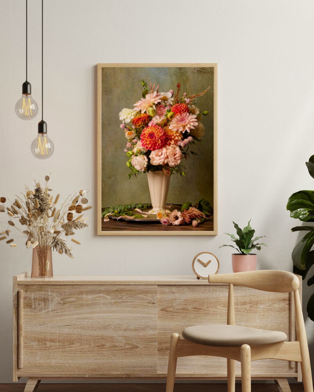 A minimalist room features the Victorian Bouquet canvas wall art. Beneath it, a wooden sideboard holds dried flowers and a small plant, while a light-colored chair sits close by under hanging light bulbs.