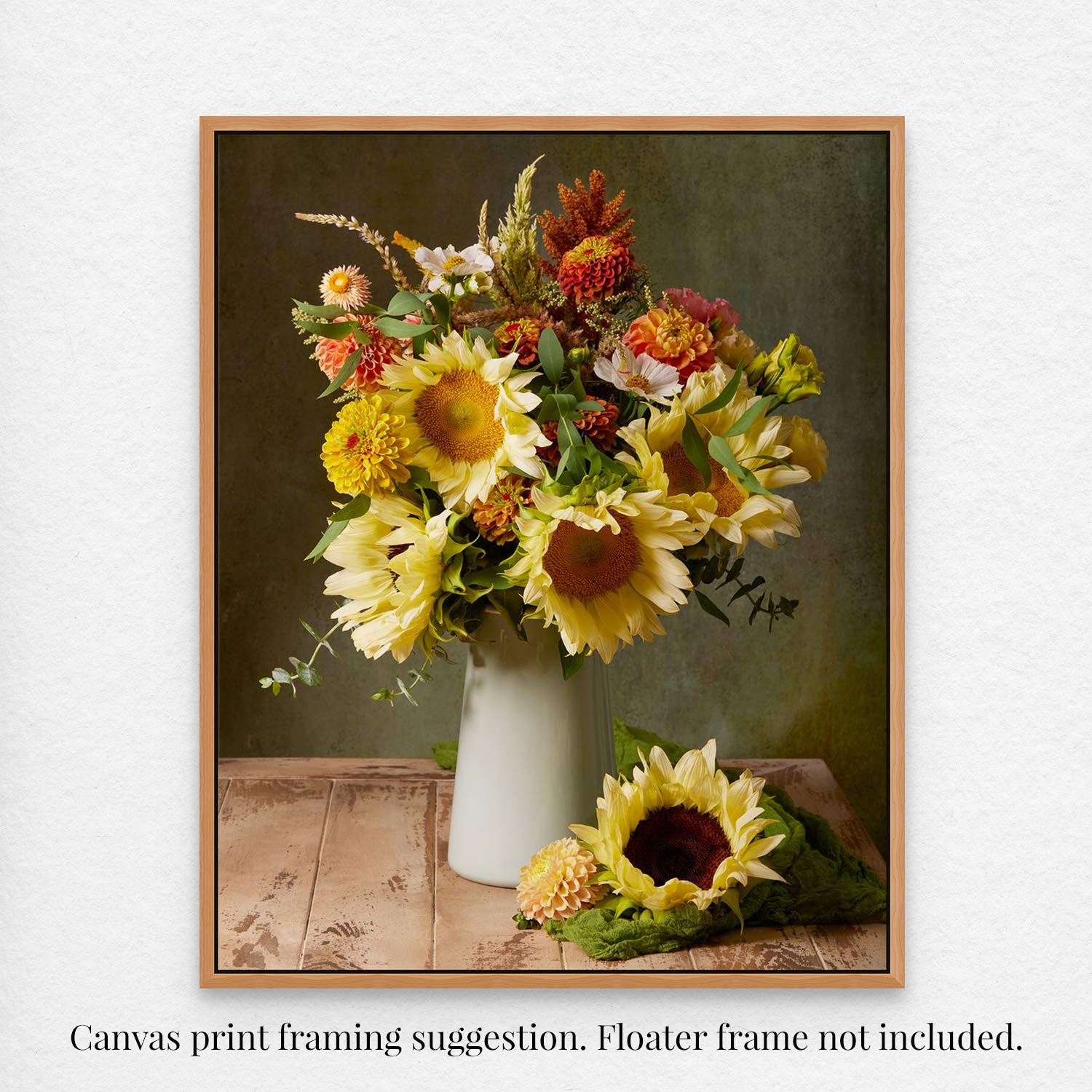 The Sunny Bouquet canvas art shows a rustic sunflower arrangement with daisies and greenery in a white vase on wood against a green backdrop. A single sunflower rests beside it. Text overlay suggests: Canvas wall art framing suggestion. Floater frame not included.