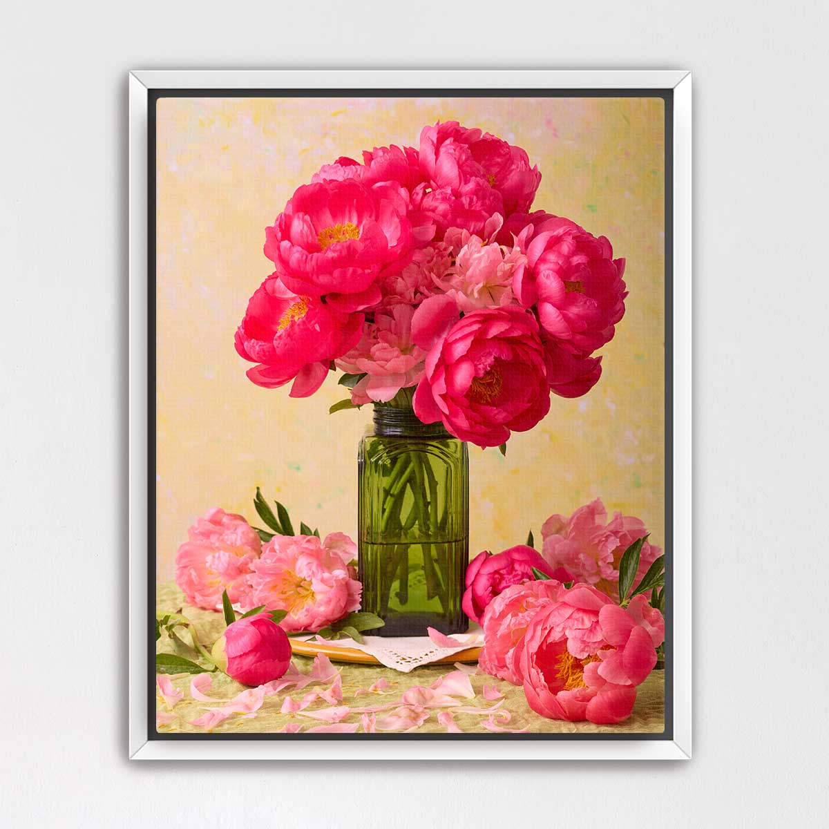 A bouquet of vibrant pink peonies in a green vase, surrounded by additional pink peonies, creating a visually striking floral arrangement.