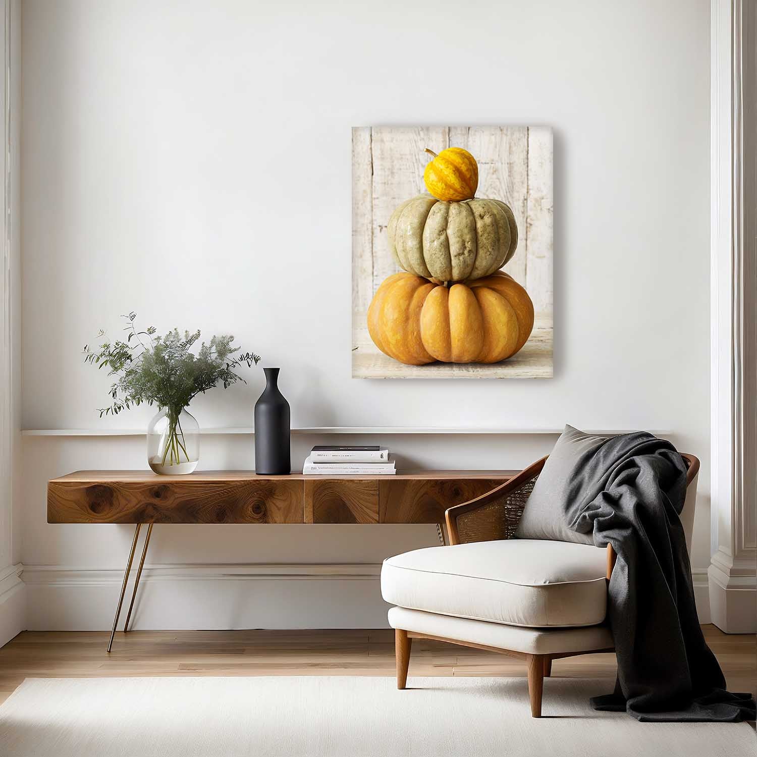 Modern living room with a wooden console table, white armchair, and decorative pumpkin canvas print called Autumn Balance.
