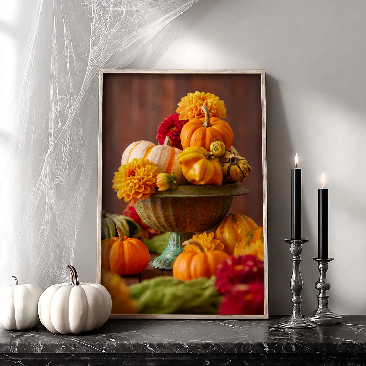 Maple framed canvas of pumpkins and dahlias on a table with candles and spider webs.