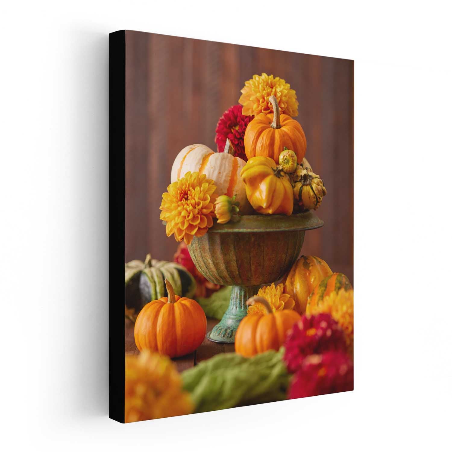 Canvas print on a white wall of pumpkins and dahlias on a wooden table with a brown background