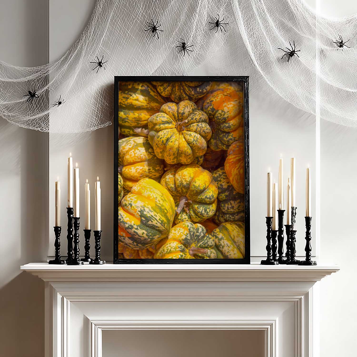 Halloween-themed decor with pumpkins, candles, and spider webs on a fireplace mantle.