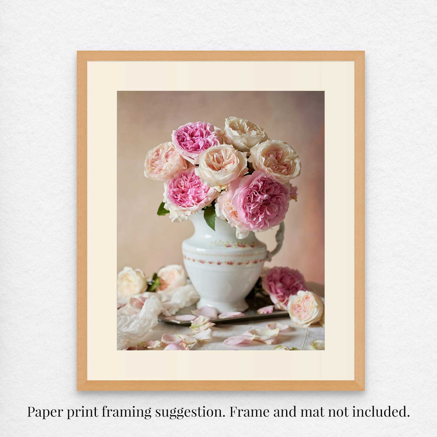 The Romance in Bloom fine art print framed showcases pink and white David Austin roses in a white vase with a soft, neutral background and scattered petals for elegance. Frame and mat are not included.