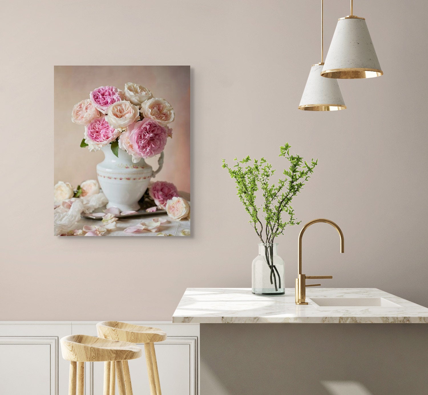 A minimalist kitchen showcases a marble countertop with a tall faucet, wood bar stools, and a small vase with green branches. The Romance in Bloom canvas art of pink and white David Austin roses in a vase adds elegance, while hanging pendant lights complete the decor.