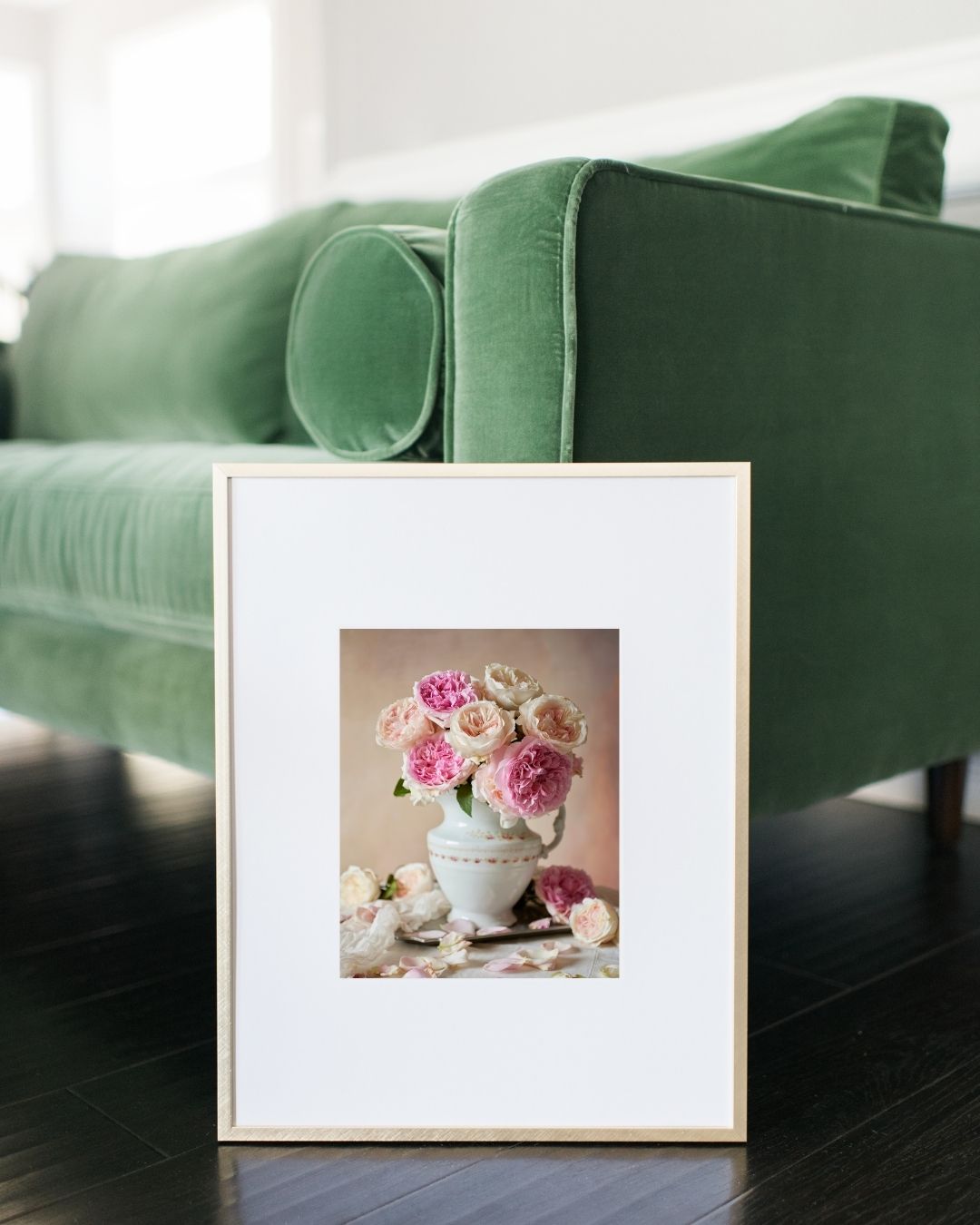 Image of the Romance in Bloom paper print framed and leaning against a green velvet couch. 