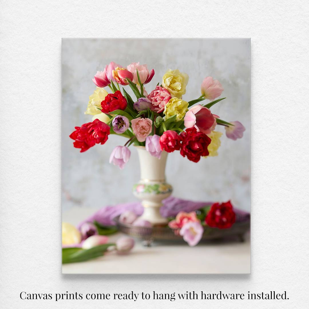 The Spring Symphony canvas wall art showcases pink, red, and yellow tulips in a vase against a gentle backdrop. This tulip wall art canvas print comes ready to hang with hardware included.