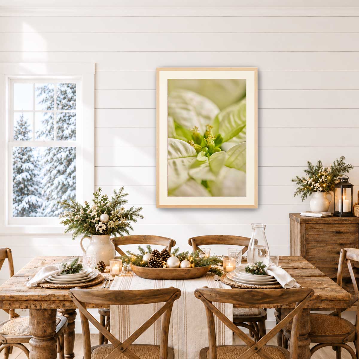 Christmas poinsettia wall art print in a Maple frame with softly blurred bracts, shown above a rustic dining table.