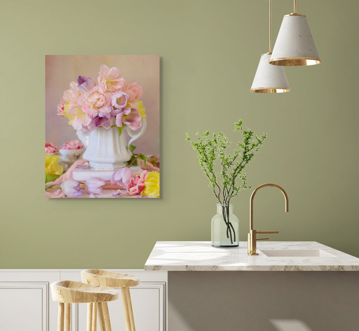 A modern kitchen featuring a marble countertop, wooden stools, hanging pendant lights, and a vase with green twigs on the counter. The soft green wall is adorned with Teapot of Blooms canvas art depicting pink and yellow flowers in a white pitcher.