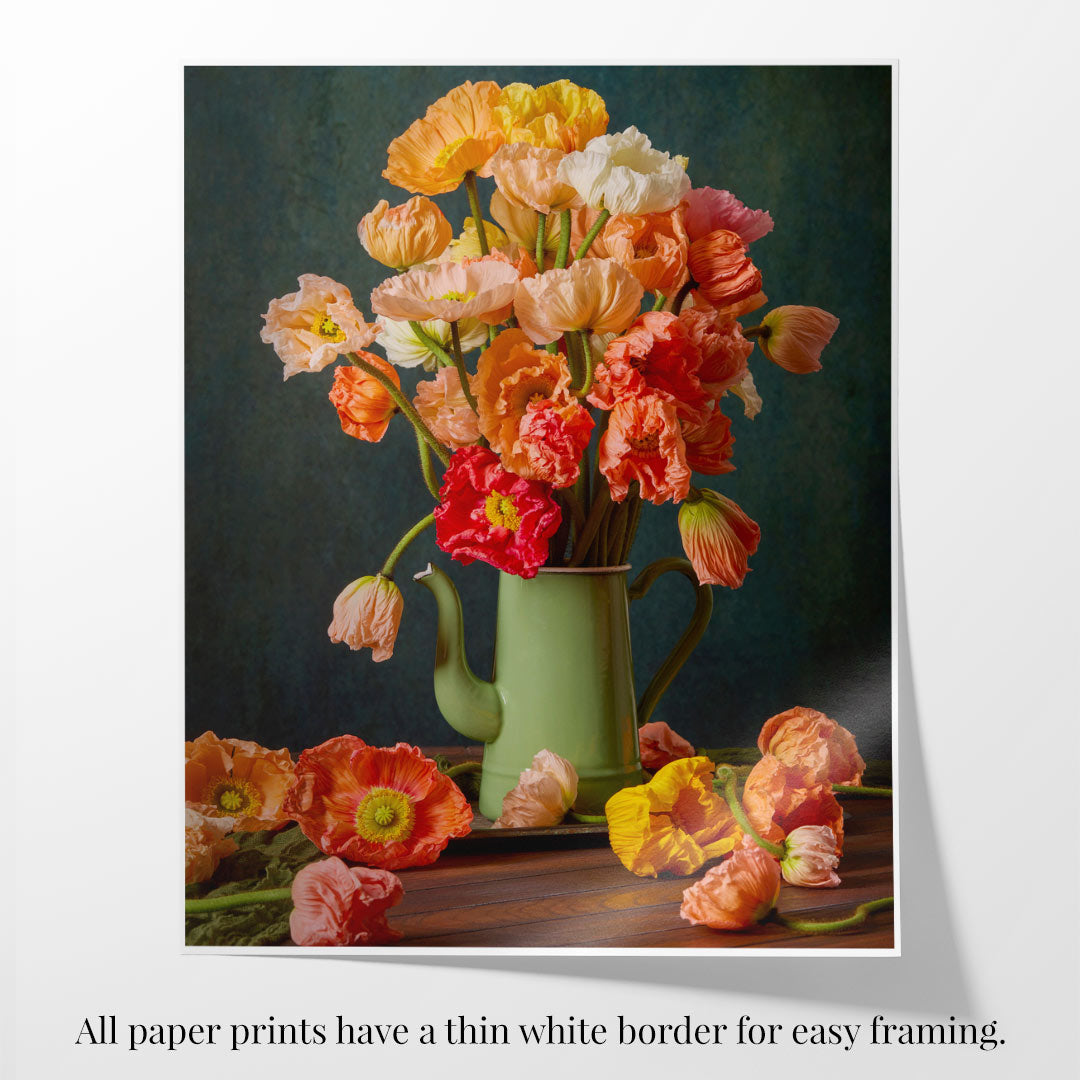 The Poppy Sisters Portraits - 3 Piece features a bouquet of vibrant pastel poppies in orange, red, and yellow shades arranged in a green teapot. Some are scattered on wood, and the still-life image has a thin white border with a note for easy framing.