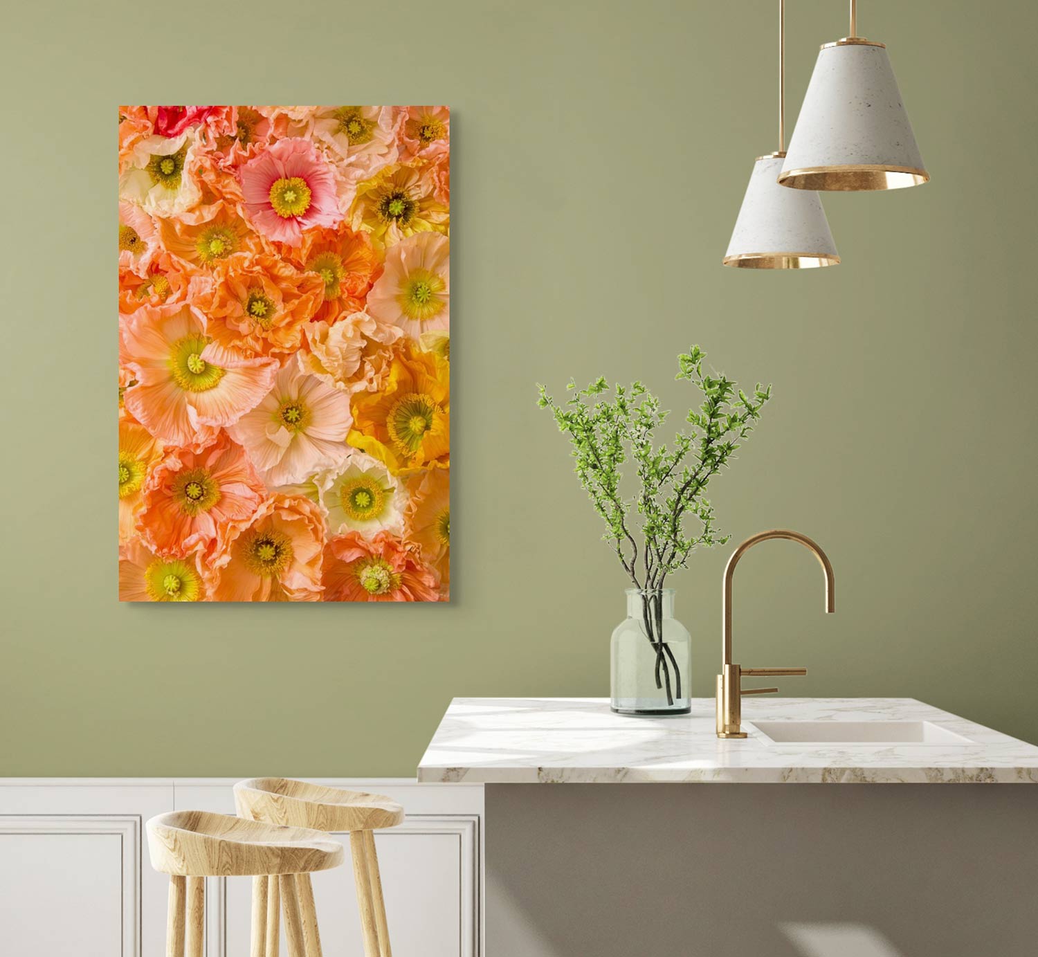 The Petals of Light canvas wall art, featuring vibrant orange and pink flowers, is displayed on a sage green wall above a white counter with wooden stools. A vase filled with greenery and two pendant lights enhance the modern kitchen decor, adding an artistic touch.