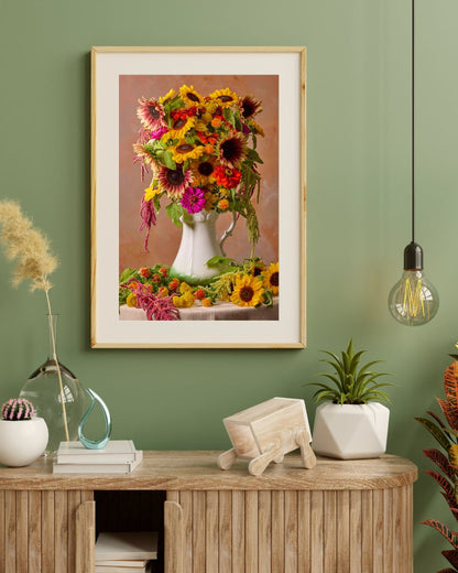 A cozy interior showcases a wooden console adorned with plants and decor. Above, the Golden Fiesta, a fine art print of vibrant sunflowers in a white vase, is set against a green wall. To the right, a single bulb pendant light casts soft illumination.