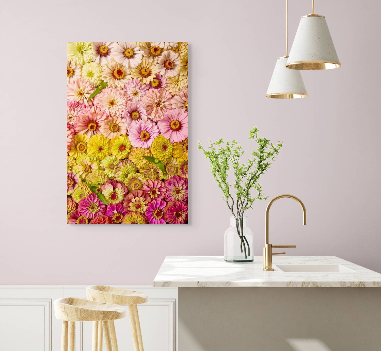 A modern kitchen, with a light pink wall and marble countertop, features two pendant lights and a wooden stool. The space is adorned with the Zinnias Dawn To Dusk canvas wall art, while a small plant in a vase gracefully sits on the counter.