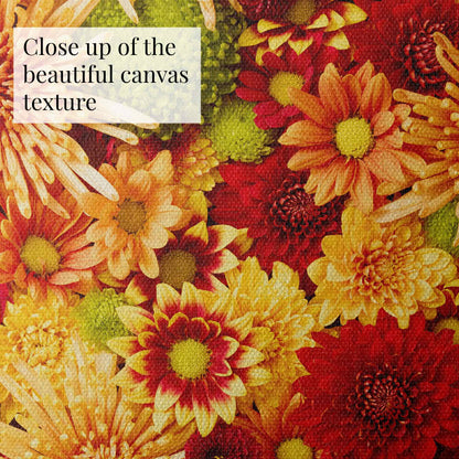 A close-up of the vibrant floral Chrysanthemum Bed - Autumns Embrace canvas features a woven texture with an autumnal palette of red, orange, and yellow flowers. The corner text reads, Close up of the beautiful canvas texture.