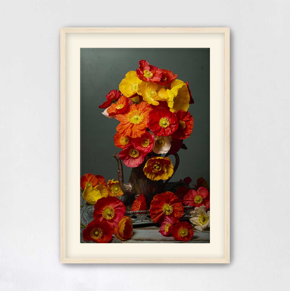 A framed image of a vase filled with vibrant red, orange, and yellow flowers, set against a dark background.