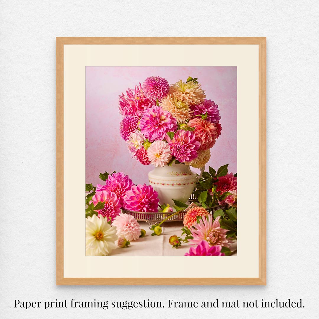 The Summer Afternoon framed  and matted print showcases a vibrant floral arrangement with pink, orange, and cream dahlias in a vintage-style white vase against a soft pink background. Note: Frame and mat not included; framing suggestion only.