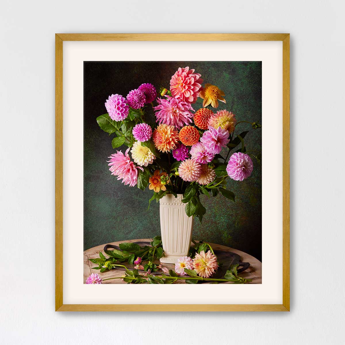 A framed image of a vase filled with a variety of colorful dahlias, including pink, orange, and yellow flowers, set against a dark green background.