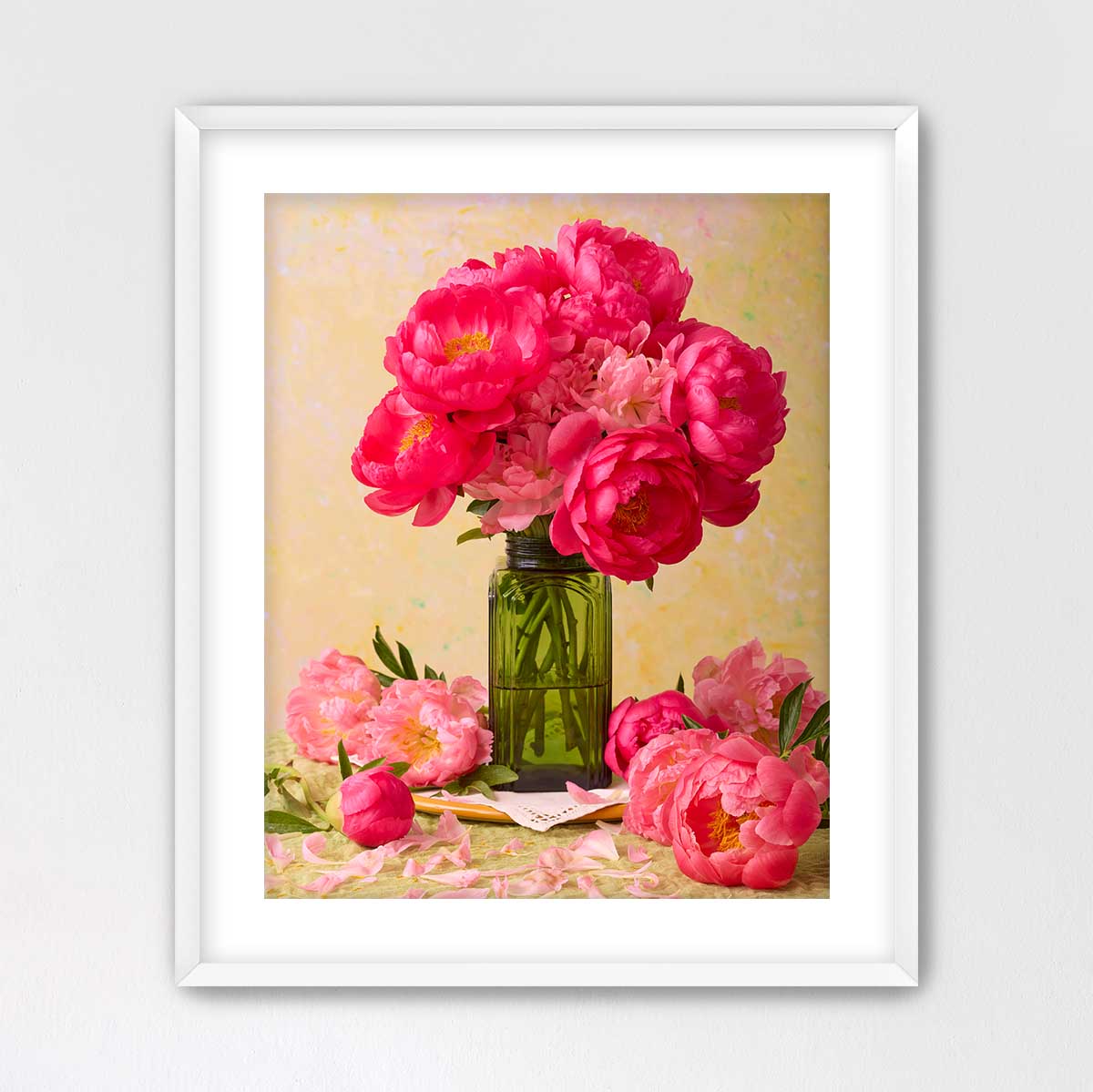 A framed image of a bouquet of pink peonies in a green vase, surrounded by additional pink peonies and a green vase.