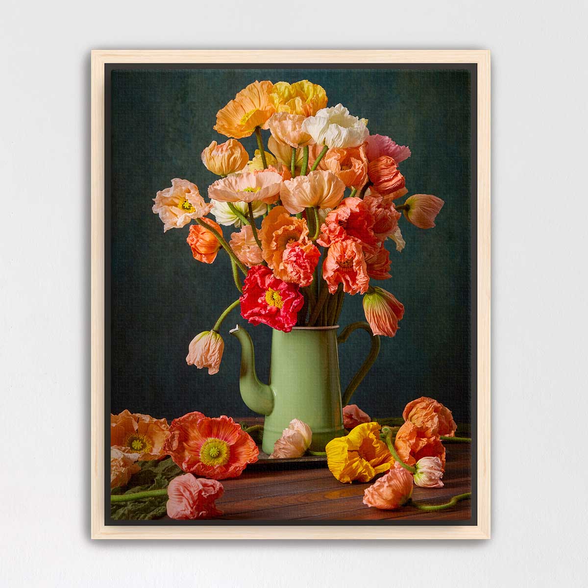 A framed still life painting depicting a vase filled with vibrant orange and pink flowers, surrounded by additional flowers on a wooden surface.