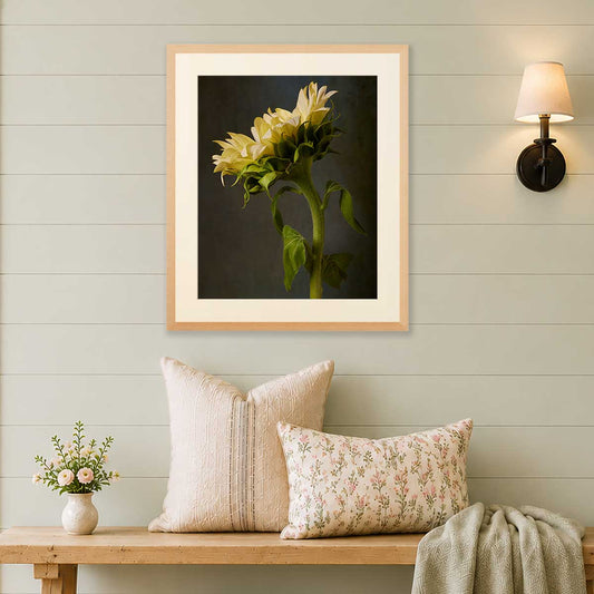 Sunny Sass Sunflower Wall Art Print in a gold frame with cream mat, shown above a sofa cushion