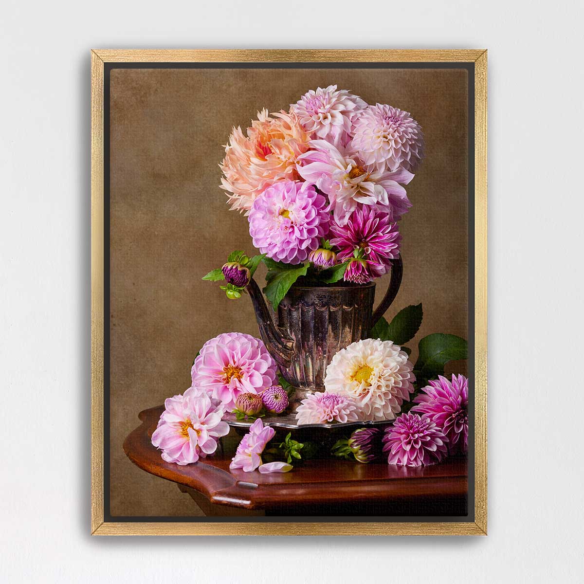 A framed still life photograph depicting a vase filled with a variety of colorful dahlias, including pink, orange, and white flowers, placed on a wooden table.