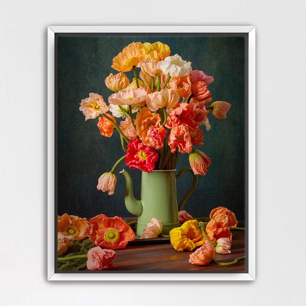 A framed still life painting depicting a vase filled with vibrant orange and pink flowers, surrounded by additional flowers on a wooden surface.