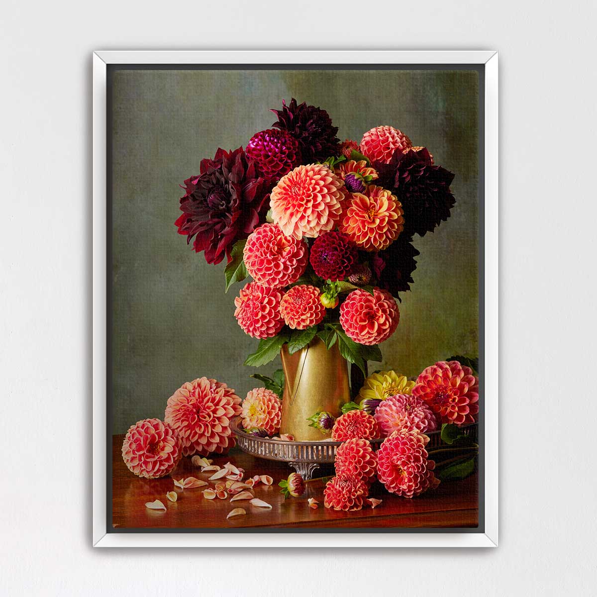 A framed still life painting depicting a vase filled with a variety of colorful dahlias, including red, pink, and yellow flowers, along with some additional flowers on a wooden surface.