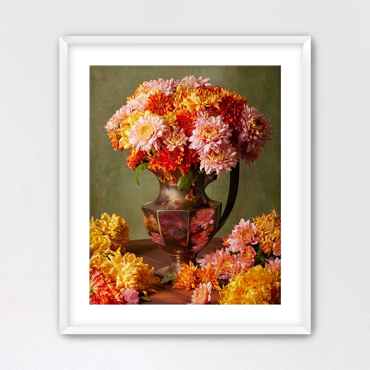 A framed image of a vase filled with a vibrant bouquet of colorful flowers, including pink, orange, and yellow blooms, placed on a wooden surface.