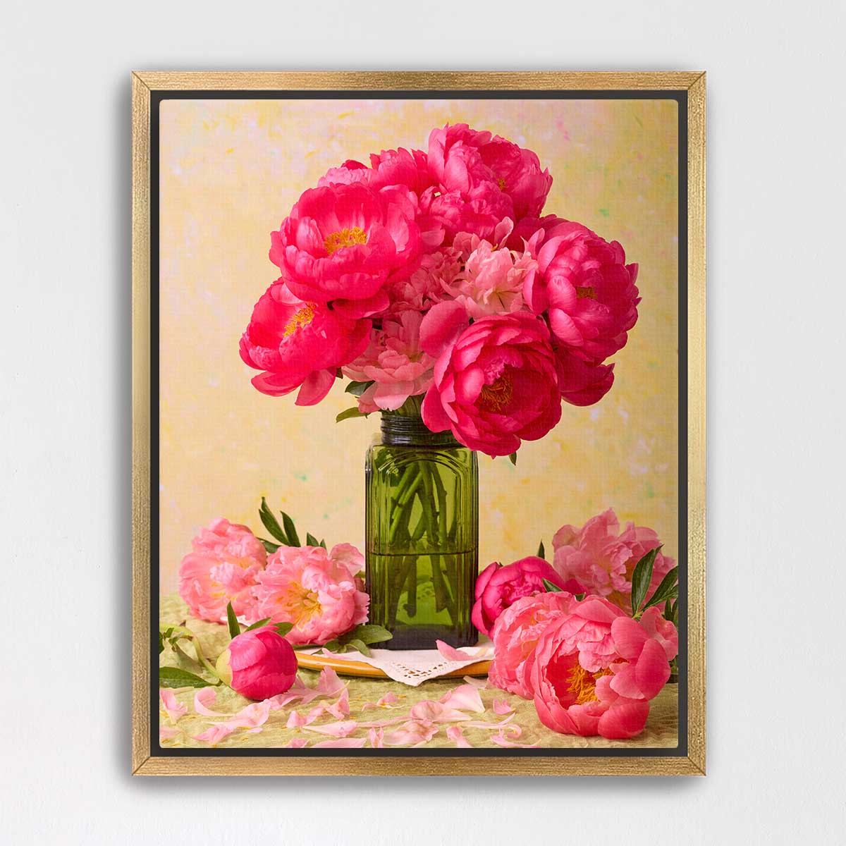 A framed image of a bouquet of vibrant pink peonies in a green vase, surrounded by additional pink peonies and leaves.