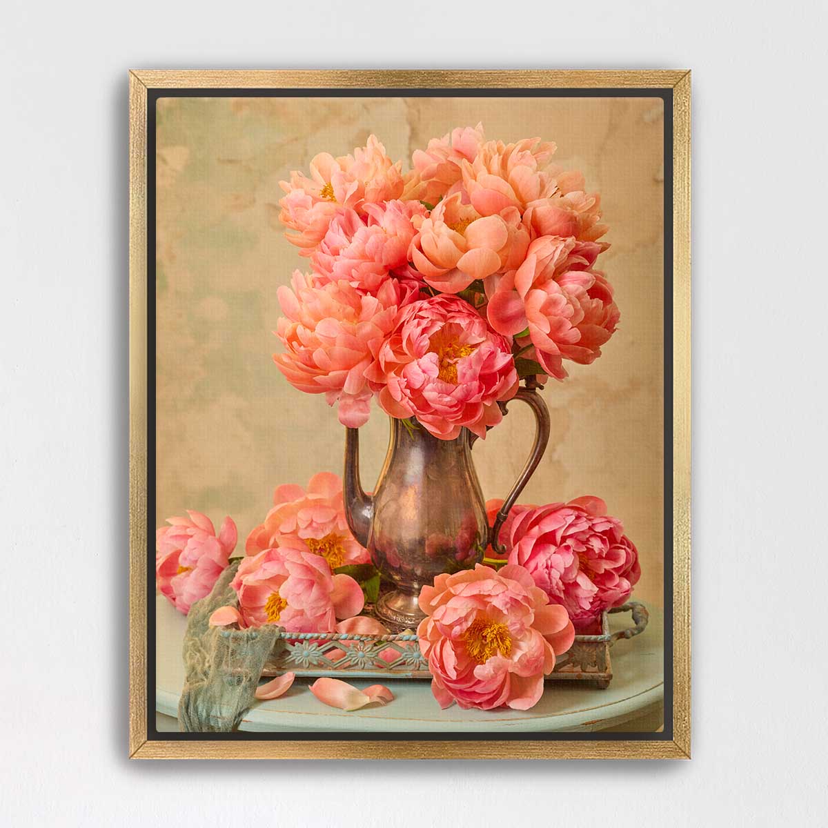A framed image of a vase filled with vibrant pink peonies, placed on a table with additional peonies.