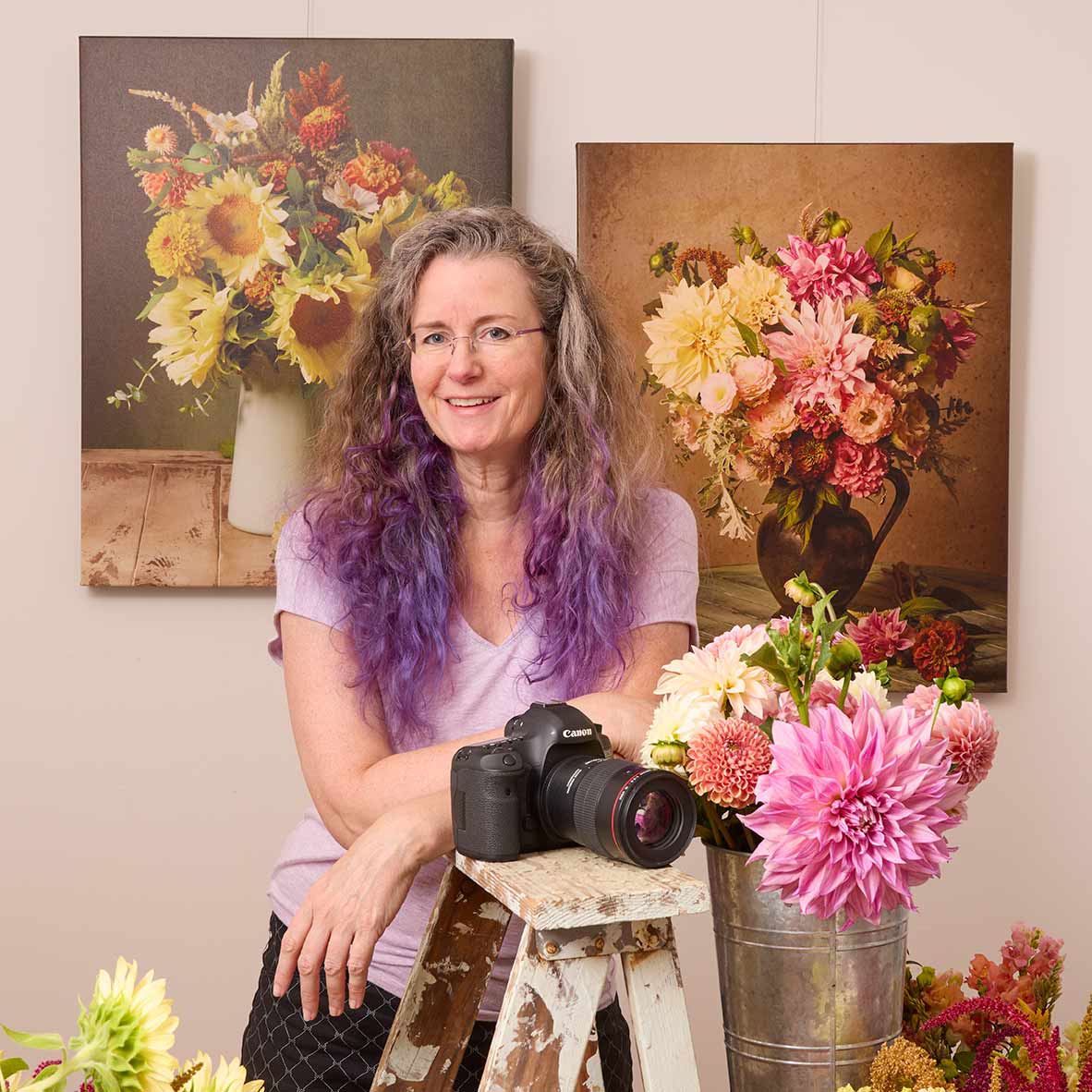 Image of Christina Peters fine art photographer in her studio with two prints behind her