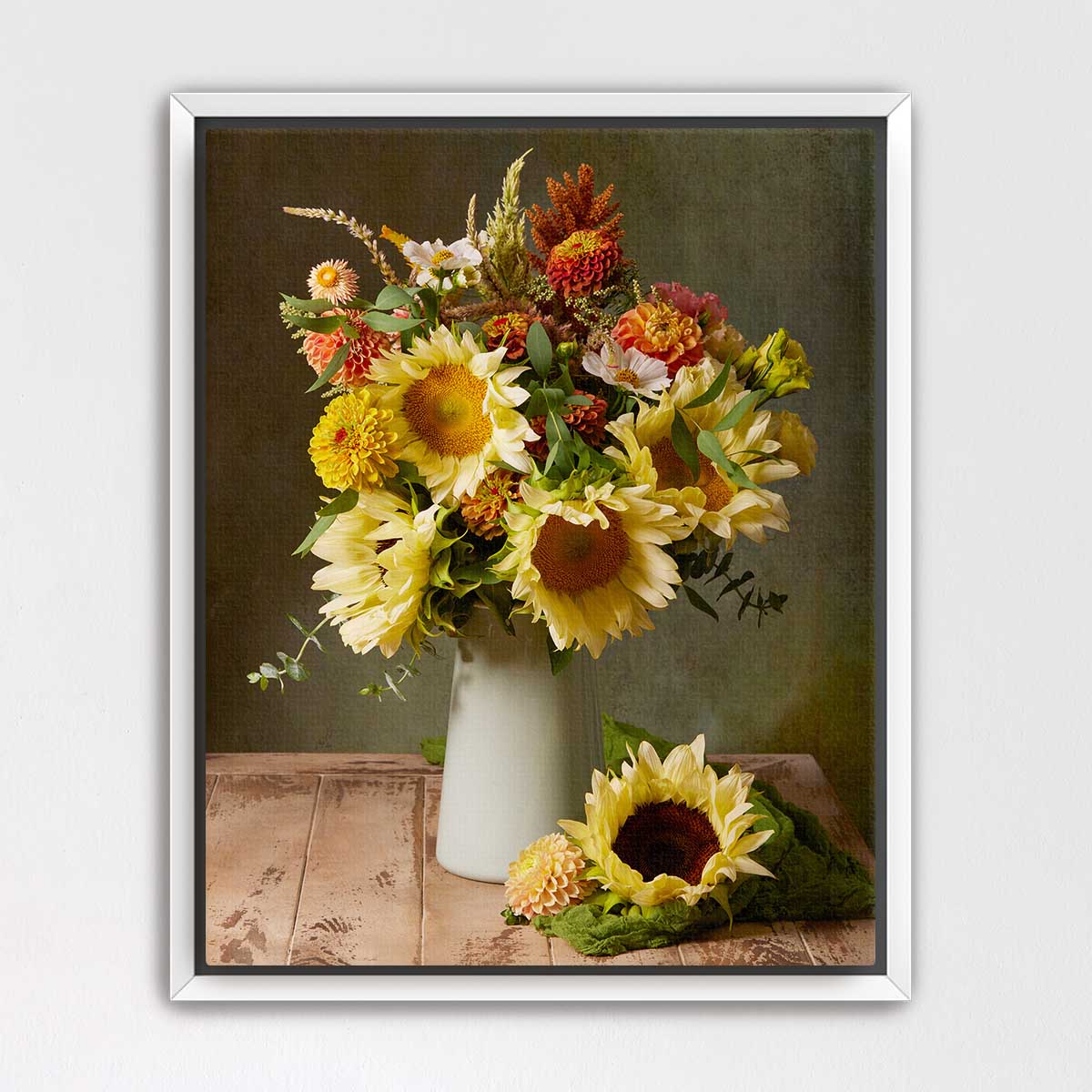 A bouquet of vibrant yellow sunflowers in a white vase, placed on a wooden surface against a neutral background.