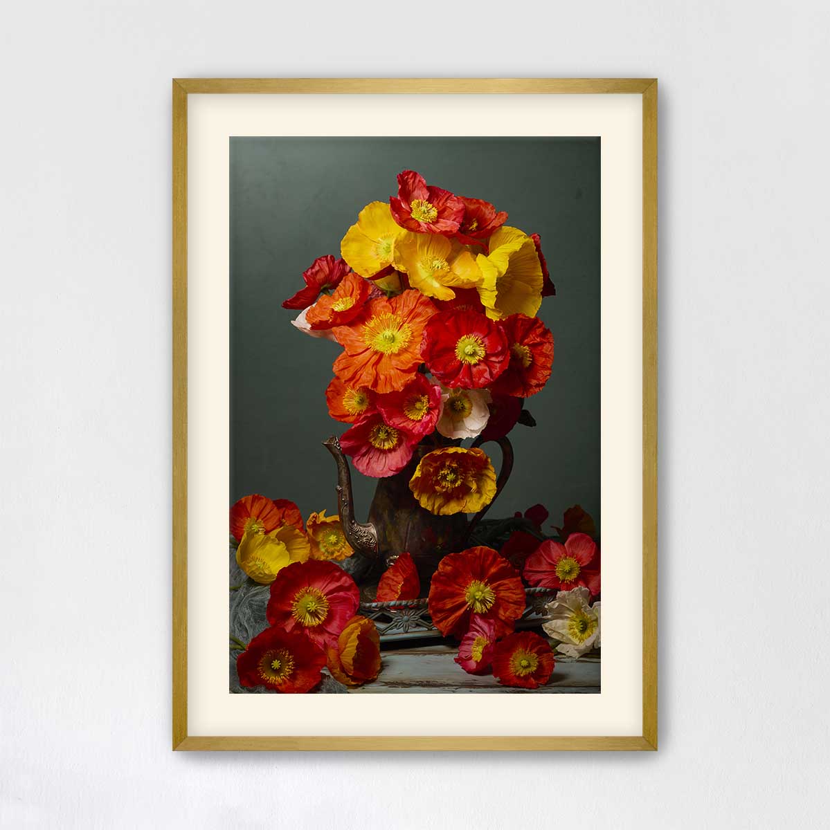 A framed image of a vase filled with vibrant red, orange, and yellow flowers, set against a dark background.