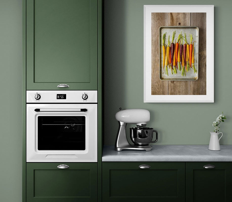 Image of the print Organic Raw Carrots framed in white on the wall of a green kitchen